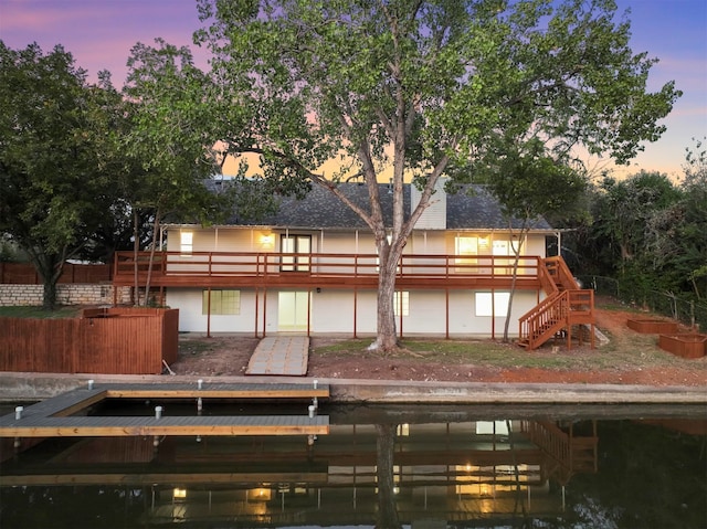 back house at dusk with a wooden deck