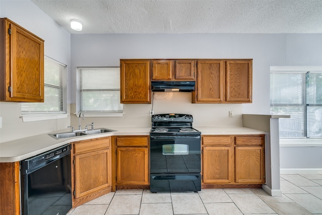 kitchen with a wealth of natural light, light tile patterned floors, and black appliances