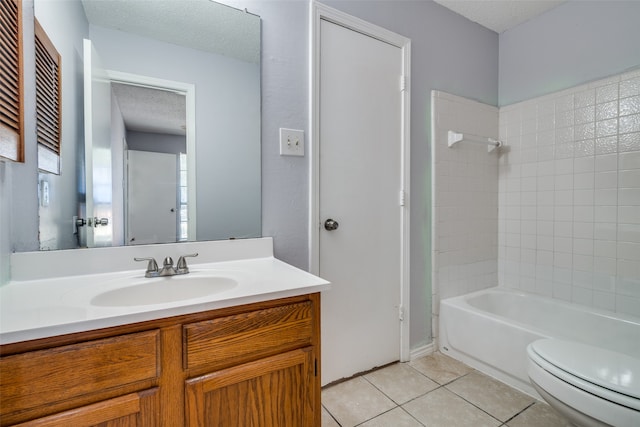 full bathroom featuring a textured ceiling, tile patterned floors, vanity, tiled shower / bath, and toilet