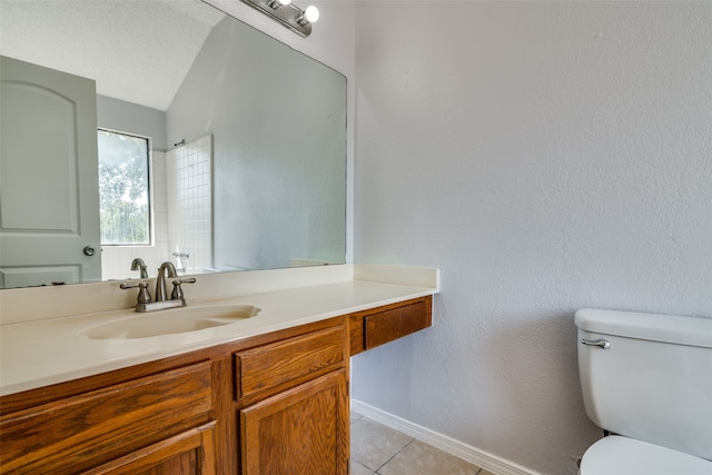 bathroom featuring vanity, tile patterned flooring, toilet, and a textured ceiling