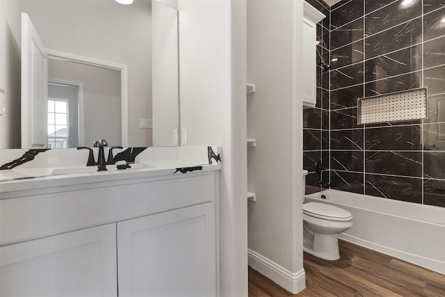 full bathroom featuring vanity, wood-type flooring, tiled shower / bath combo, and toilet