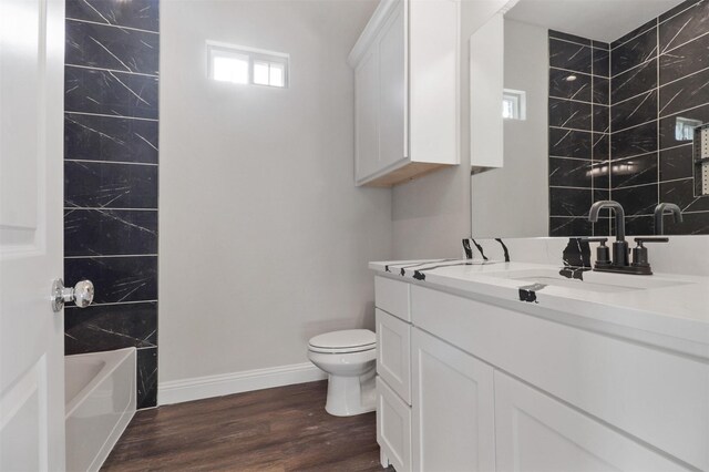 full bathroom featuring vanity, toilet, wood-type flooring, and tiled shower / bath