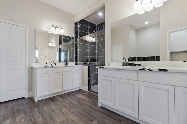 bathroom with hardwood / wood-style floors, vanity, walk in shower, and tile walls