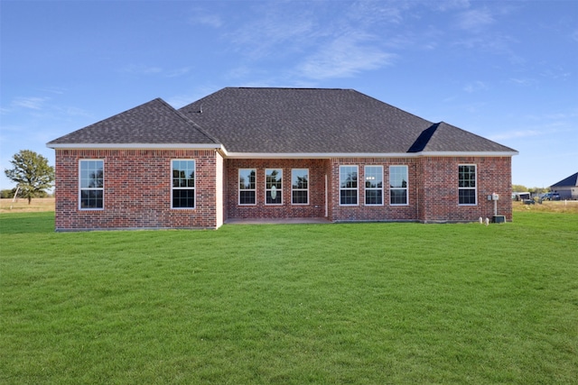 rear view of property featuring a lawn