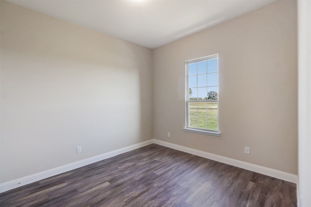 unfurnished room with dark wood-type flooring