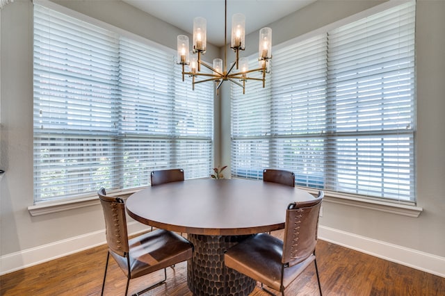 dining room with hardwood / wood-style floors and an inviting chandelier