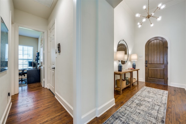 interior space featuring ornamental molding, an inviting chandelier, and dark wood-type flooring