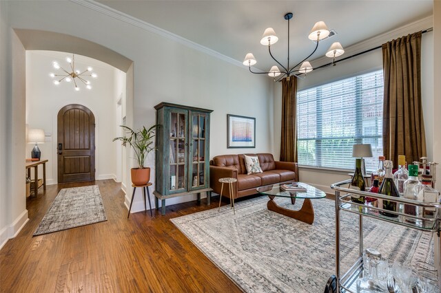 living room featuring a notable chandelier, crown molding, and dark hardwood / wood-style flooring