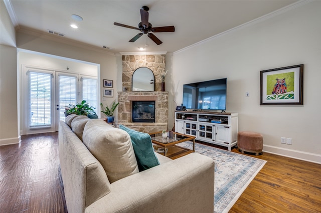 living room featuring a fireplace, dark hardwood / wood-style floors, crown molding, and ceiling fan