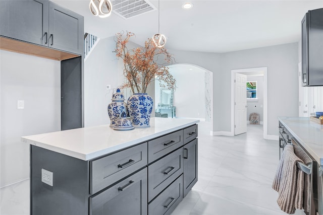 kitchen featuring gray cabinetry, a center island, and decorative light fixtures