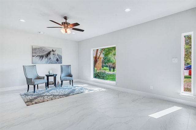 living area with ceiling fan and plenty of natural light