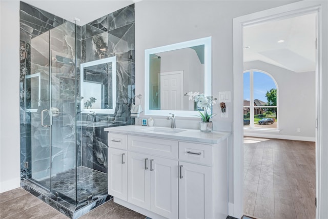 bathroom with vaulted ceiling, walk in shower, hardwood / wood-style flooring, and vanity