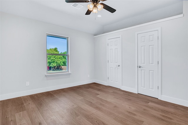 unfurnished bedroom with light wood-type flooring, vaulted ceiling, and ceiling fan