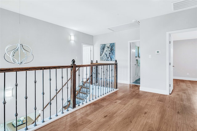 corridor featuring light hardwood / wood-style flooring and a chandelier