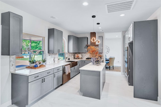 kitchen with pendant lighting, a center island, sink, wall chimney exhaust hood, and stainless steel appliances