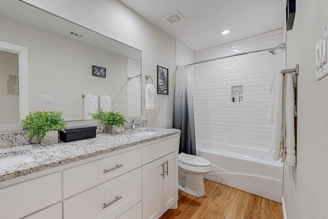 full bathroom featuring shower / bath combo, hardwood / wood-style floors, vanity, and toilet