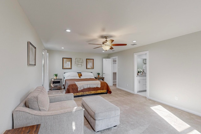 bedroom featuring connected bathroom, ceiling fan, and light colored carpet