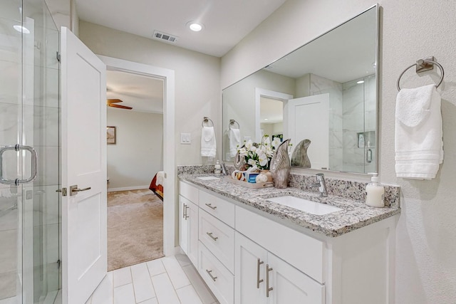 bathroom featuring tile patterned floors, ceiling fan, walk in shower, and vanity