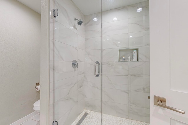 bathroom featuring an enclosed shower and toilet