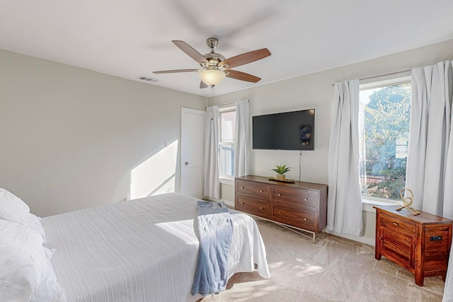 carpeted bedroom featuring ceiling fan and multiple windows