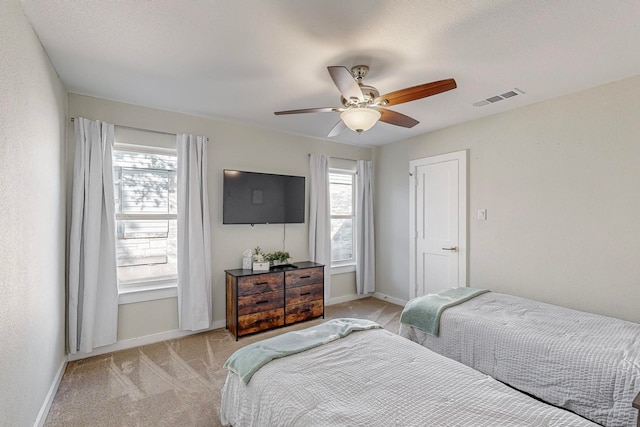 carpeted bedroom with multiple windows, a textured ceiling, and ceiling fan