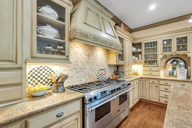 kitchen featuring cream cabinets, light stone countertops, stainless steel range, and dark wood-type flooring