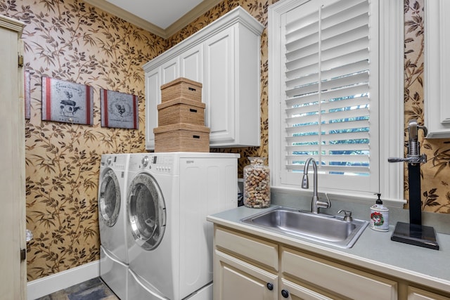 washroom featuring washing machine and clothes dryer, crown molding, cabinets, and sink