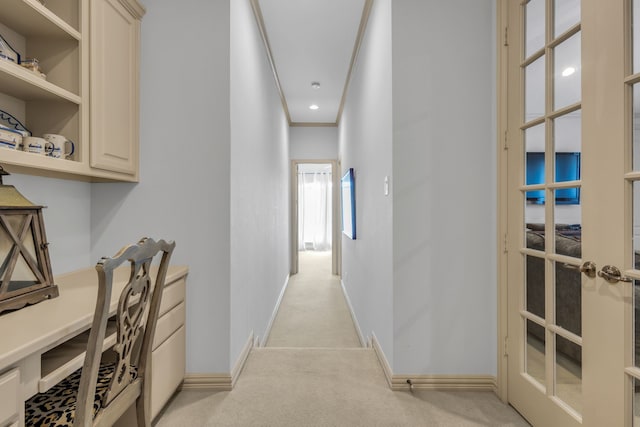 corridor with ornamental molding and light colored carpet