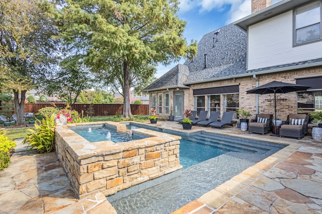 view of swimming pool featuring an in ground hot tub and a patio area