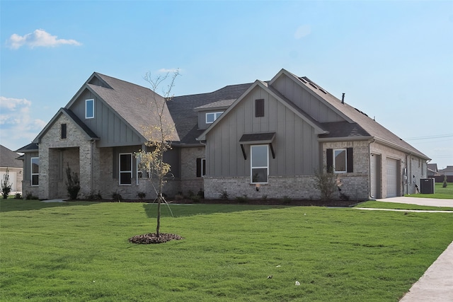 view of front of property with a garage, cooling unit, and a front lawn