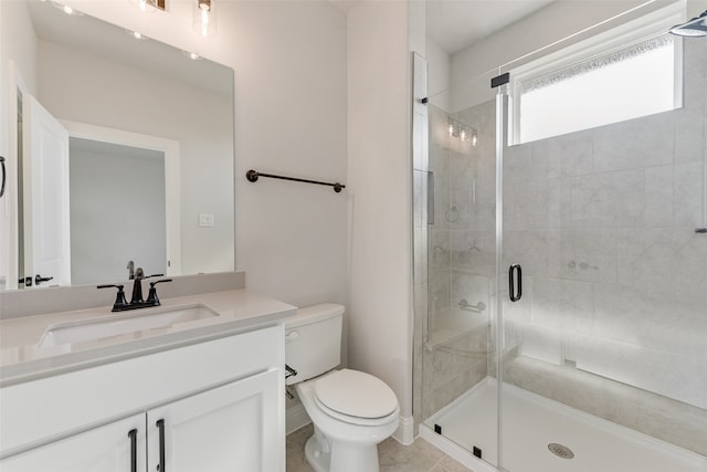 bathroom featuring vanity, a shower with shower door, toilet, and tile patterned flooring