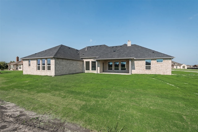 rear view of property featuring a yard