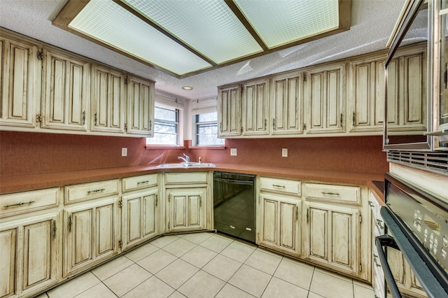 kitchen featuring black appliances, a textured ceiling, light tile patterned floors, and sink