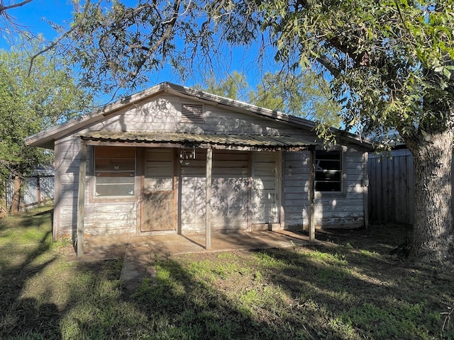 rear view of house with a yard, a garage, and an outdoor structure