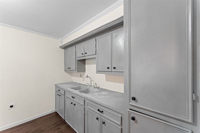 kitchen with sink, gray cabinets, dark hardwood / wood-style floors, ornamental molding, and a textured ceiling