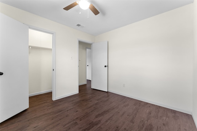 unfurnished bedroom with ceiling fan, dark hardwood / wood-style floors, and a closet