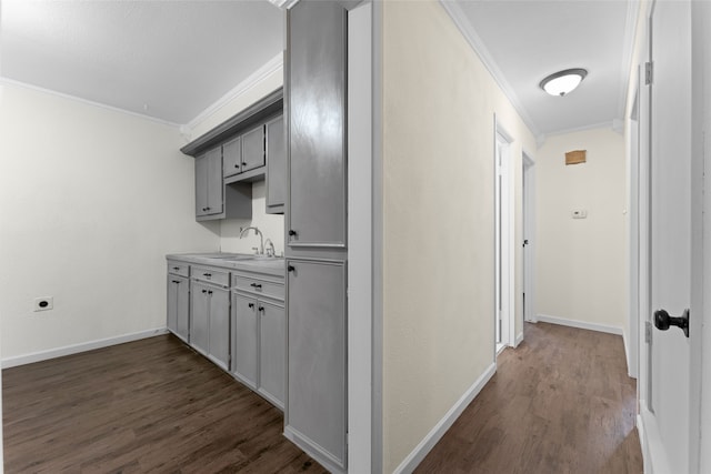 hall with sink, crown molding, and dark wood-type flooring