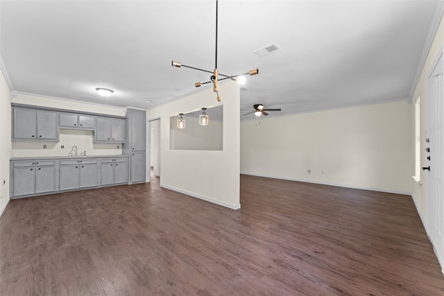 unfurnished living room with dark hardwood / wood-style floors, sink, and ornamental molding