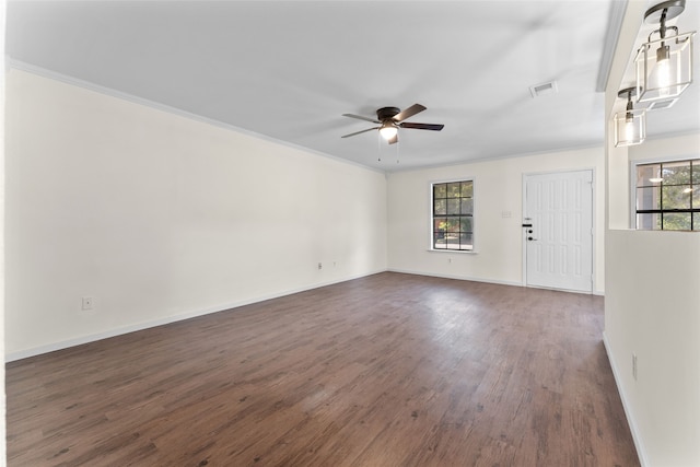 spare room featuring dark wood-type flooring, plenty of natural light, ornamental molding, and ceiling fan