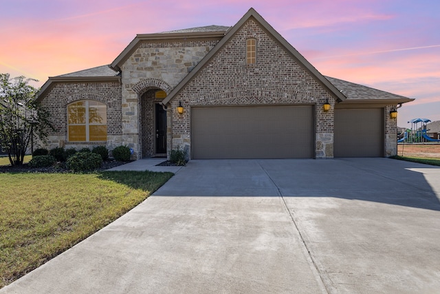 view of front of home featuring a garage and a yard