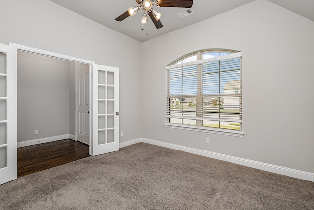 carpeted empty room with built in features, vaulted ceiling, ceiling fan, and french doors