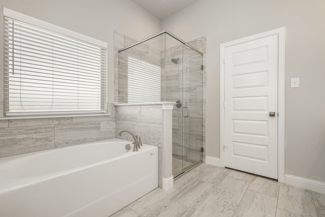 bathroom featuring shower with separate bathtub