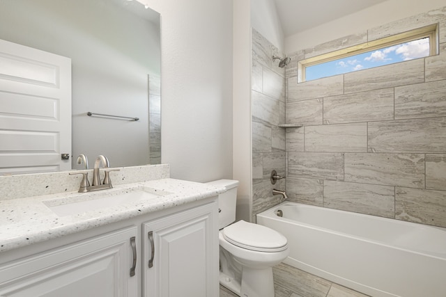 full bathroom featuring tiled shower / bath combo, vanity, and toilet