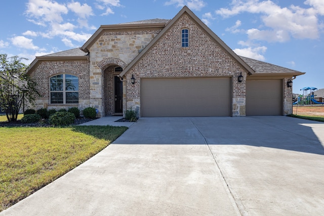 view of front facade featuring a front yard and a garage