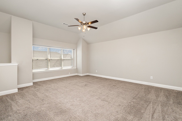 carpeted spare room with ceiling fan and lofted ceiling