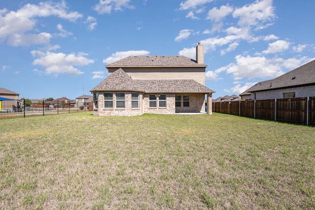 rear view of house featuring a lawn