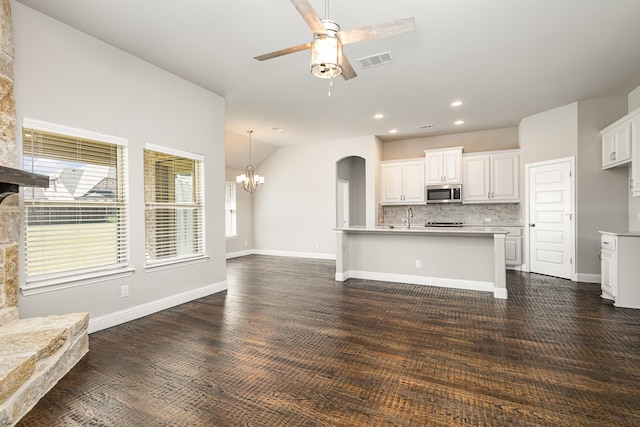 unfurnished living room featuring vaulted ceiling, ceiling fan with notable chandelier, dark hardwood / wood-style floors, and sink