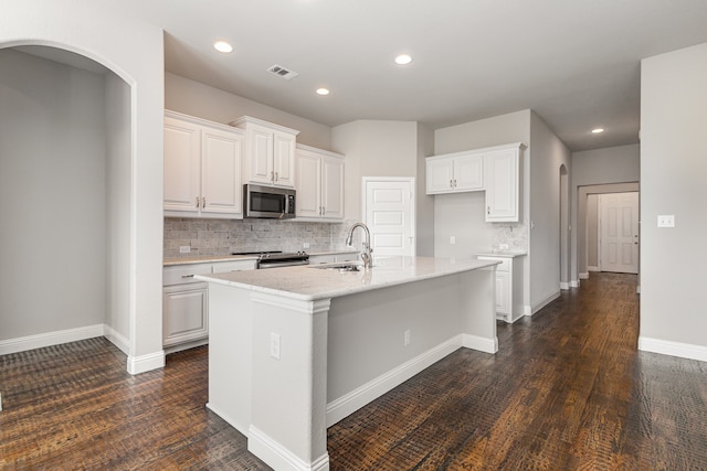 kitchen featuring appliances with stainless steel finishes, a kitchen island with sink, dark wood-type flooring, and white cabinets