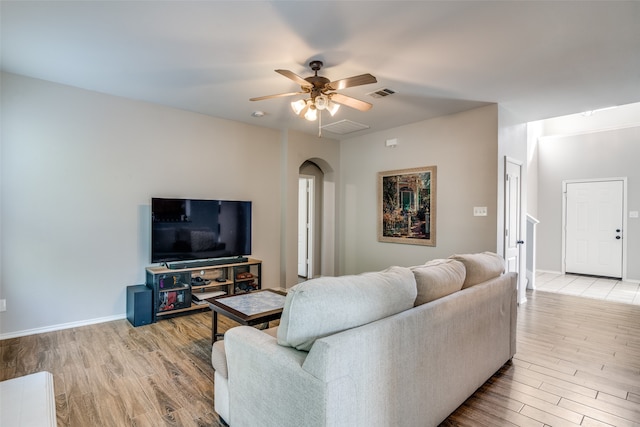 living room featuring light hardwood / wood-style flooring and ceiling fan