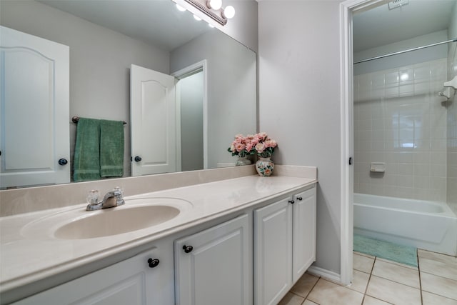 bathroom with tile patterned floors, vanity, and tiled shower / bath